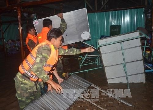 Border troops help people move their stuff after 20m of the Nha Mat sea dyke was breached in the Mekong Delta province of Bac Lieu (Photo: VNA)